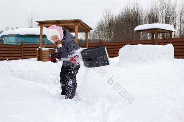 女孩用铲子把雪从跑道上<strong>拿下</strong>来