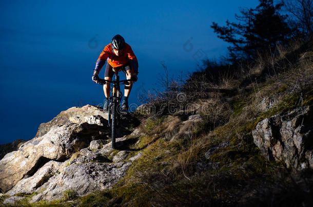 恩杜罗自行车者晚上骑自行车在岩石上。 极限运动概念。 文本的空间。