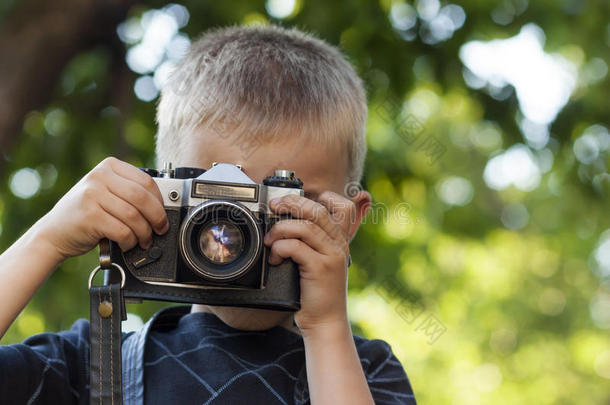 可爱的小快乐男孩与老式照片相机户外