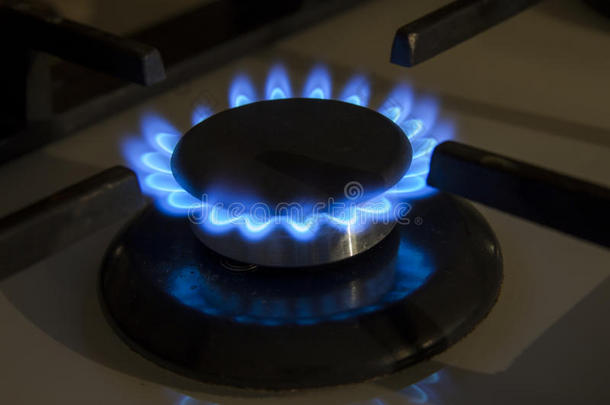 燃烧的煤气炉在黑色背景下在黑暗中燃烧蓝色的火焰
