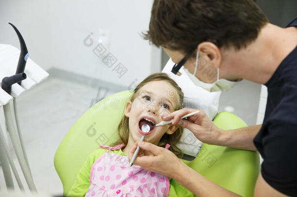 女孩坐在牙科椅上定期进行牙科检查