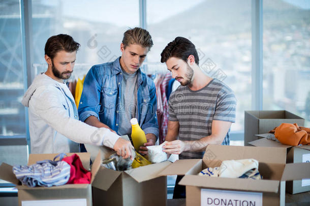 创意商业团队在捐赠箱中分拣衣服