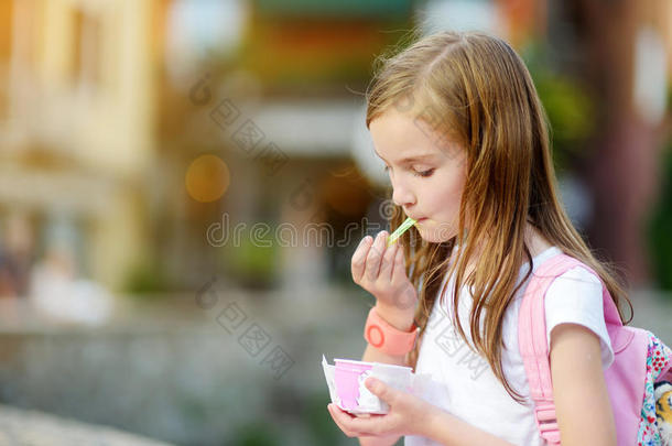可爱的小女孩在温暖的夏天在户外吃美味的新鲜冰淇淋