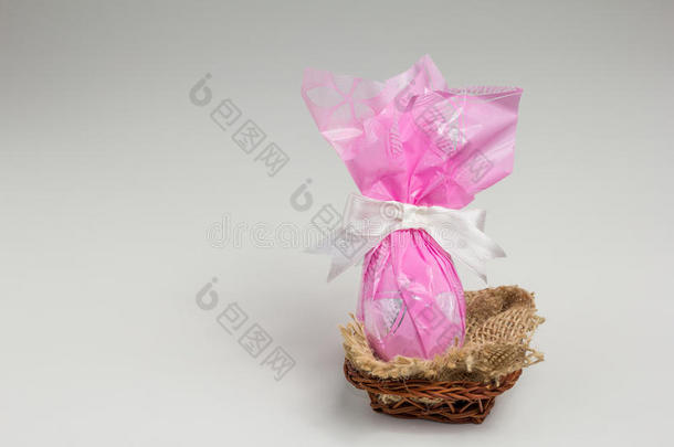 巧克力复活节彩蛋，粉红色包装<strong>在篮子里</strong>。白色背景