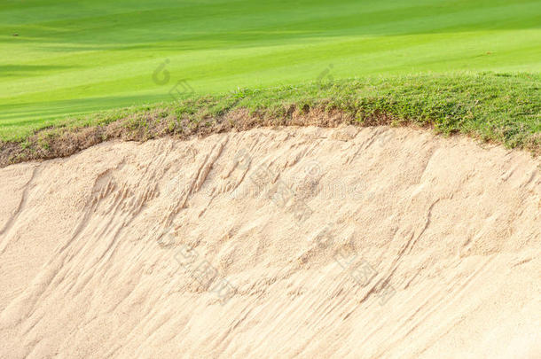 沙坑的特写边界，对比在绿色高尔夫球场的新鲜草地上。