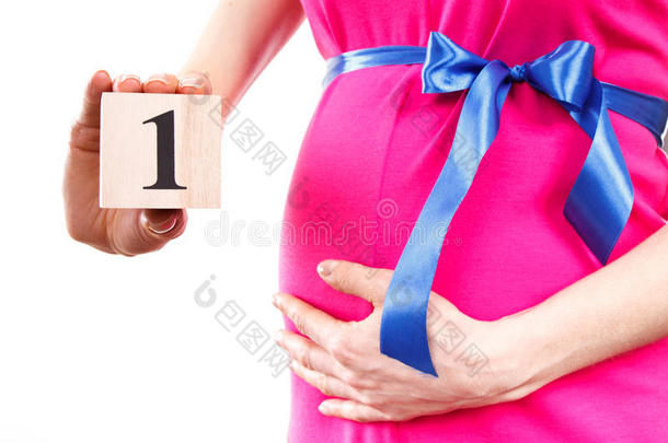 妇女的手显示怀孕第一个月的数量，期待新生儿的概念