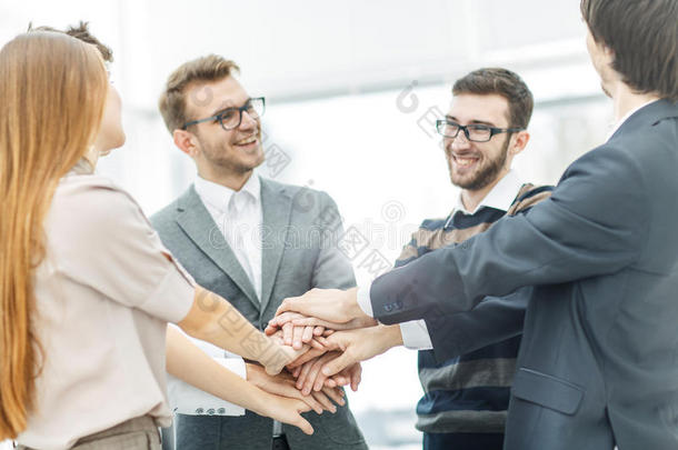 商业成功的概念：友好的商业团队站在一个圈子里，携手合作
