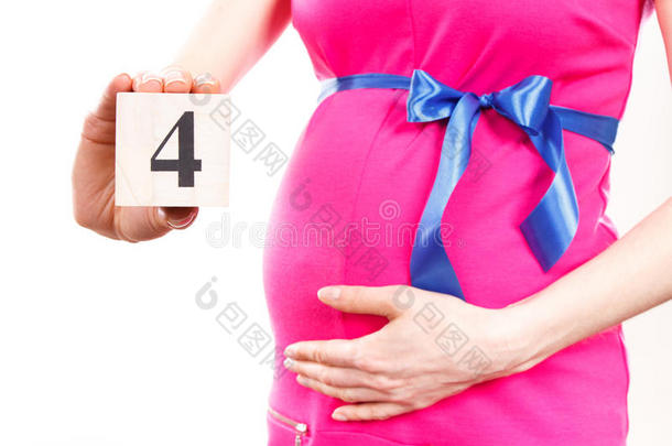 妇女的手显示怀孕第四个月的数量，期待新生儿的概念