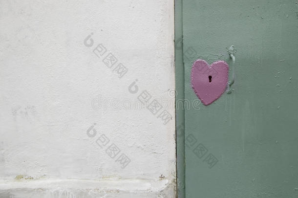 一颗心形状的门锁。 金属门。 墙。 背景