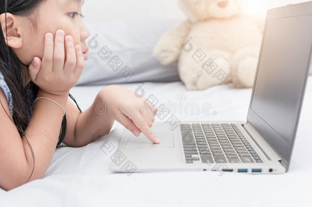 可爱的女孩玩电脑，用触控板搜索互联网。
