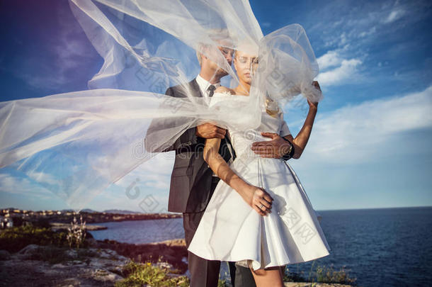 时尚的新婚夫妇在海洋附近。 新娘和新郎。 户外肖像