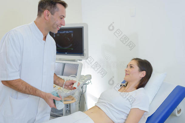 医生在诊所对腹部孕妇做超声波检查