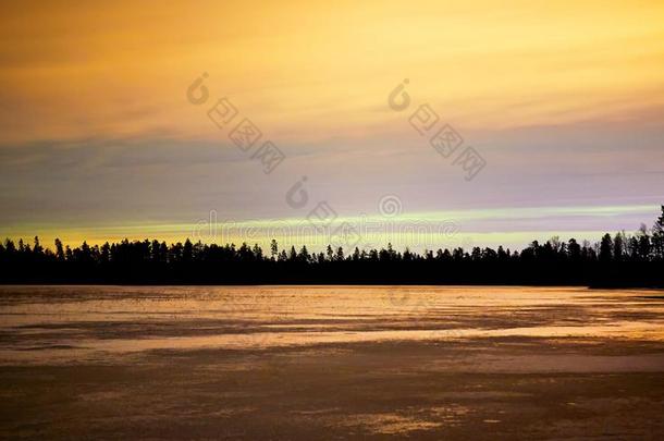 夜晚结冰的湖泊，日落，橙色的天空和冰
