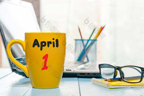 4月1日。每月的第一天，早上咖啡杯上的日历，商务办公背景，带笔记本电脑和眼镜的工作场所