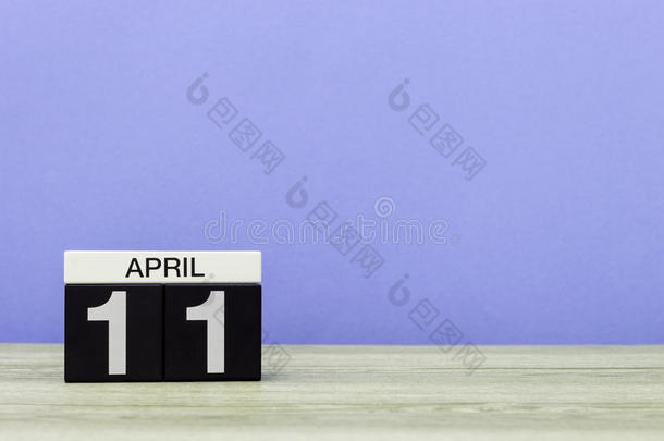 4月<strong>11</strong>日。 月<strong>11</strong>日，木桌上的日历和紫色背景。 春天的时间，文字的空空间