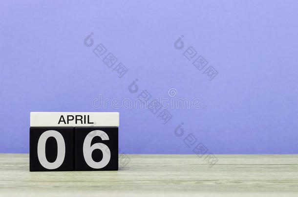 四月六日。 <strong>每月</strong>6日，木桌上的日历和紫色背景。 春天的时间，文字的空空间
