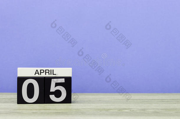 四月五日。<strong>每月</strong>的第五天，木制桌子上的日历和紫色背景。春天，文字空白