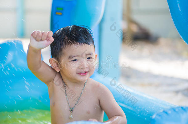 炎热的夏天，亚洲孩子在充气婴儿游<strong>泳池里玩耍</strong>