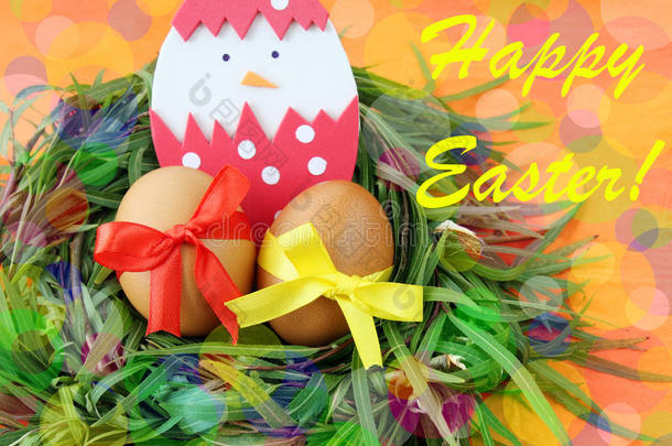 复活节手工制作贺卡：黄色的鸡蛋和手工制作的蛋壳中孵化的小鸡在绿色的草枝上筑巢，色彩鲜艳