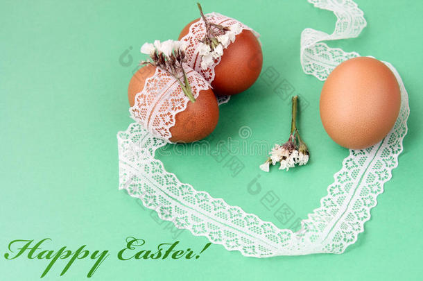 复活节手做装饰品：复活节鸡蛋与白色花边隔离在绿色背景