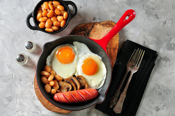 经典的<strong>早餐煎鸡蛋</strong>，香肠，蘑菇，豆类在铸铁<strong>煎</strong>锅。