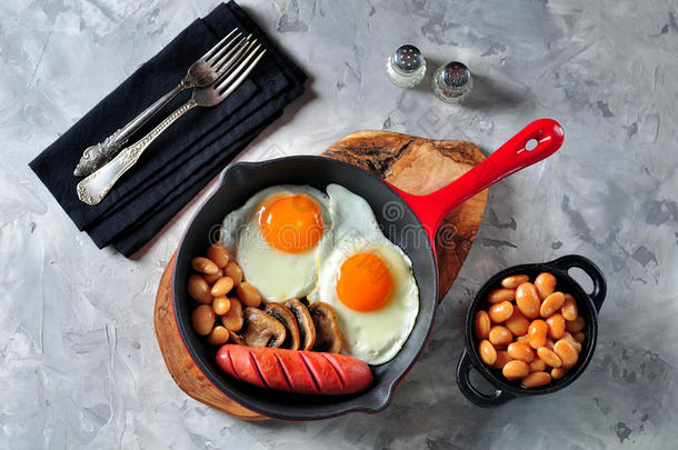 经典的早餐<strong>煎鸡蛋</strong>，香肠，蘑菇，豆类在铸铁<strong>煎</strong>锅。