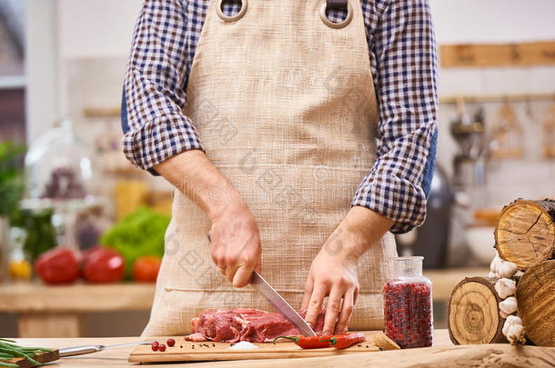 屠夫在厨房用蔬菜背景切猪肉、牛肉或羊肉牛排肉