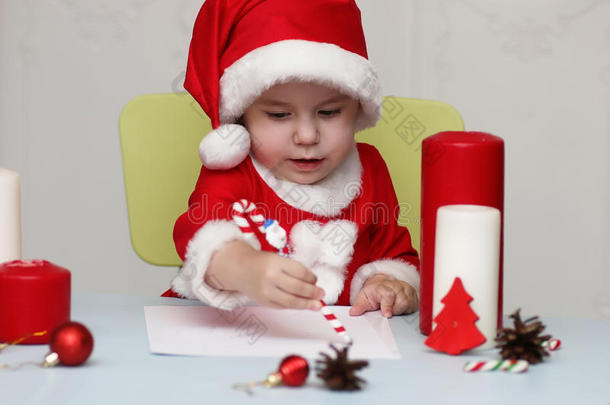 穿着圣诞老人衣服的孩子写着一封信