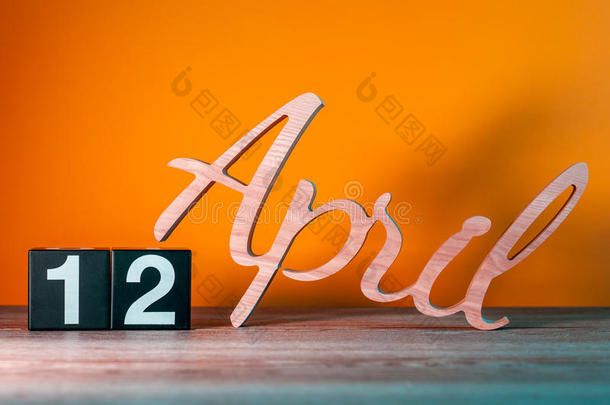 四月十<strong>二日</strong>。 每月12日，每日木制日历在桌子上，橙色背景。 春季时间概念