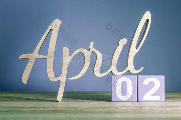 四月二日。每月的第二天，每天的日历放在紫色或紫色背景的木桌上。春季主题