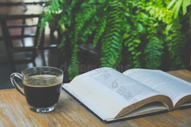 一杯咖啡和一本书放在木桌上。