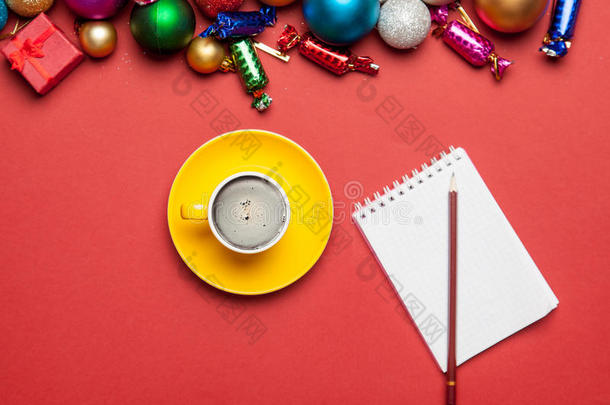 一杯咖啡，笔记本，铅笔和美丽的<strong>圣诞装饰</strong>在美妙的<strong>红色背景</strong>上