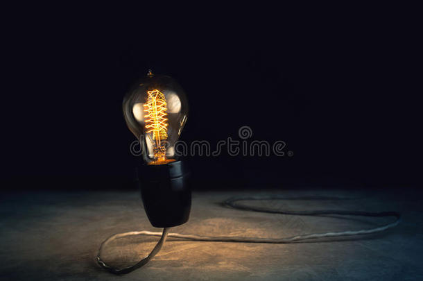 抽象亮灯泡站立与黑色背景，灯泡的想法概念。