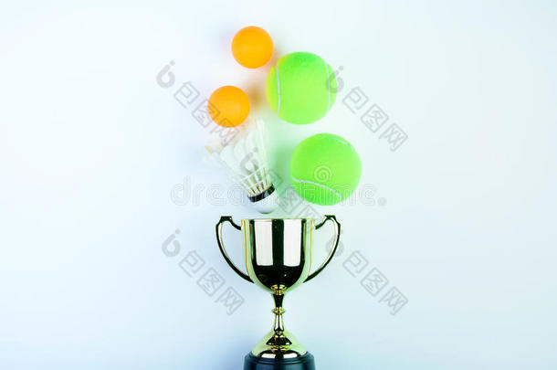 <strong>金色奖杯</strong>，毽子，乒乓球和网球隔离在白色背景与复制空间。概念赢家