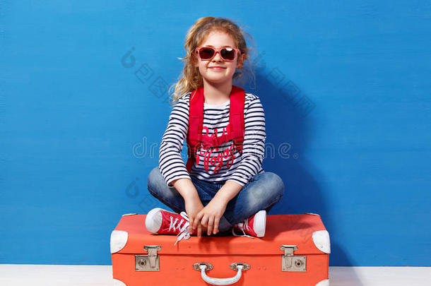 金发女孩带着粉红色的老式手提箱准备暑假。 旅行和冒险概念