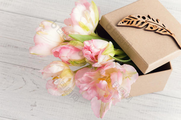 新鲜粉红色郁金香花在礼品牛皮箱