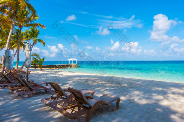 海滩椅子与伞在马尔代夫岛与白色桑迪