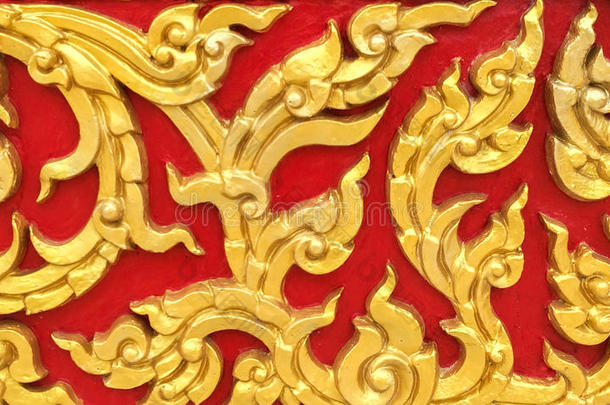 经典石刻泰国复古风格艺术的<strong>金色花</strong>无缝图案在红色混凝土背景纹理上用作美化