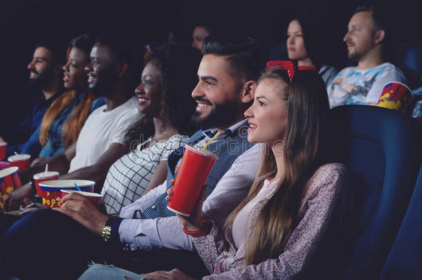 一群人在现代电影院大厅看电影。