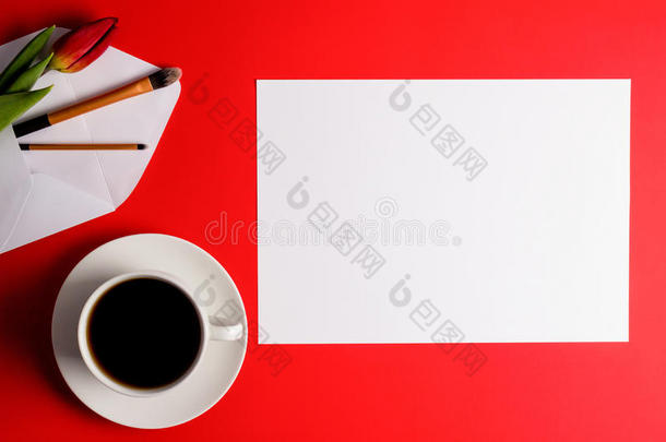 创意背景与化妆刷与信封，空白纸，咖啡杯和花在红色背景