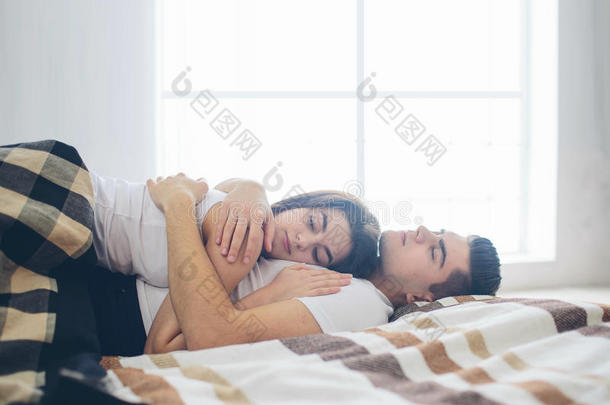 一对<strong>恩爱</strong>的<strong>夫妇</strong>躺在床上。 明亮舒适的卧室。 家庭的安慰和<strong>爱</strong>