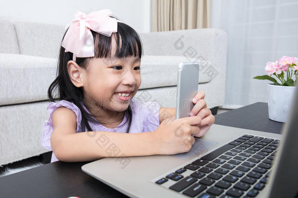 亚洲<strong>中国</strong>小女孩忙着阅<strong>读</strong>手机和笔记本电脑