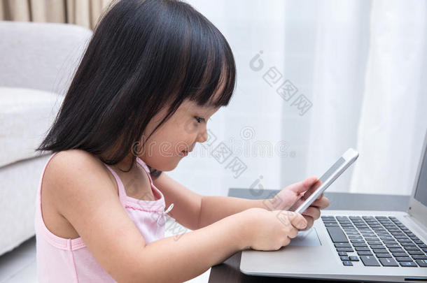 亚洲<strong>中国</strong>小女孩忙着阅<strong>读</strong>手机和笔记本电脑