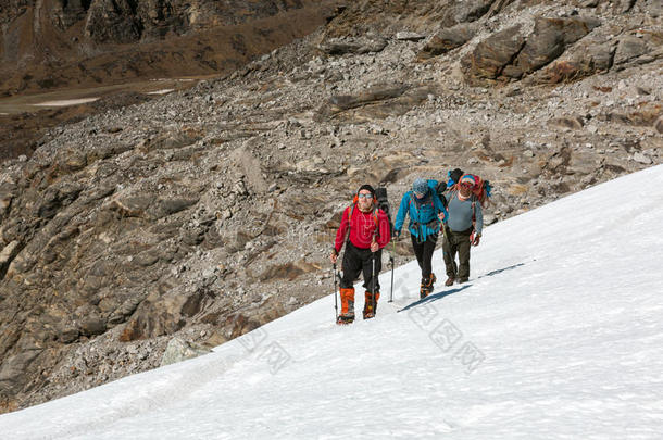 高山登山者沉重地踩在雪坡上