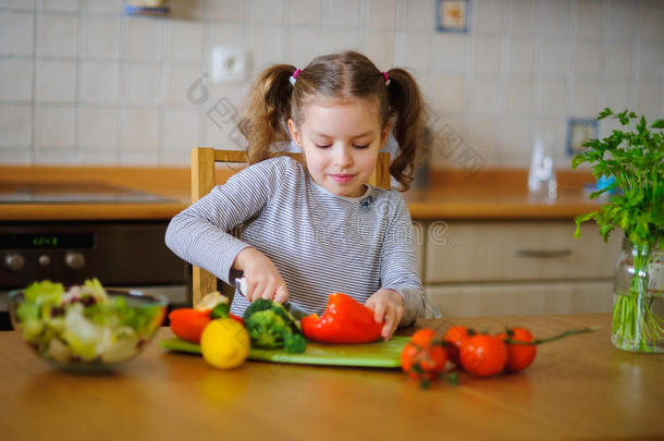 年轻学龄的<strong>可爱</strong>女孩切<strong>蔬菜</strong>和<strong>蔬菜</strong>做沙拉。