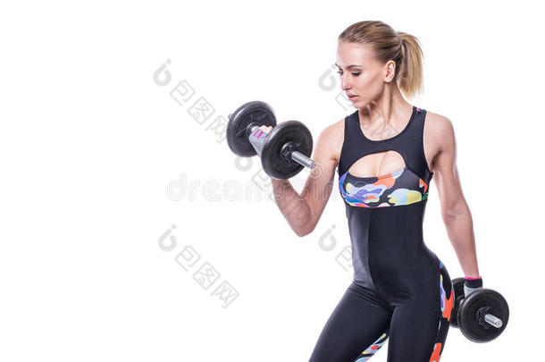 运动的年轻女人，完美的强壮的肌肉身体，穿着运动服，运动服，用哑铃泵起肌肉。