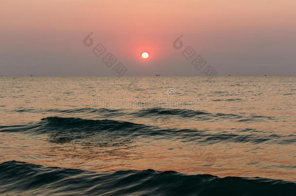 海滩日落是金色的日落天空，波浪滚滚而至