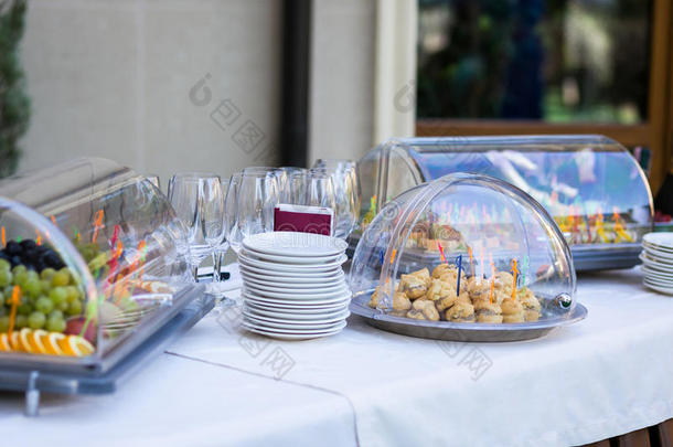 餐厅宴会的宴会桌。零食，蛋糕，空眼镜，餐具，盘子，水果在盘子上