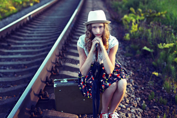 等待火车的女孩。照片以复古的风格色调。