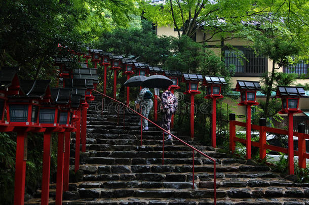 和服的女士们在雨中挣扎以衡量信仰。